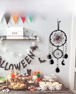 Close-up of a Halloween dreamcatcher featuring spiders and skulls in a party setting