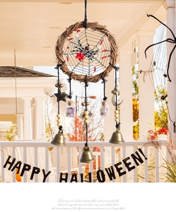 Detail of Halloween dreamcatcher with spider web, bronze bells and mini stone bottles