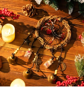 Detail of Halloween rattan wreath with black spider, bronze bells and crystal glass bottle