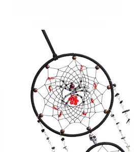 Close-up of gothic dream catcher featuring a beaded spider and white skull charms