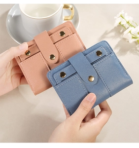 Detail von Bifold-Ledergeldbörsen in Rosa und Blau mit goldenen Druckknöpfen und Lychee-Struktur