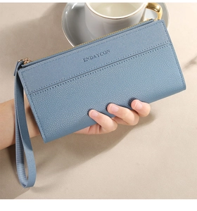 Detail van een lange damesportemonnee in blauw leer met praktische polsband
