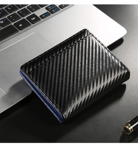 Detail of RFID carbon fiber wallet texture with navy blue trim on a business desk