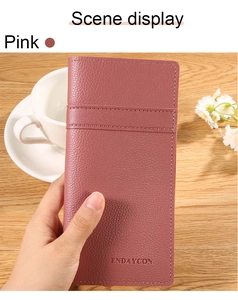 Portafoglio in pelle rosa a grana litchi tenuto in un ambiente accogliente di casa
