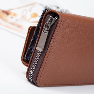 Detail of brown Saffiano wallet showing sturdy gunmetal zipper and textured finish