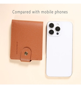 Brown lychee leather card holder shown next to a smartphone for size comparison