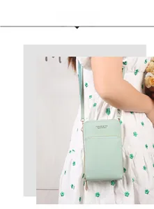 Detail showing mint green leather textured crossbody phone bag with gold lettering