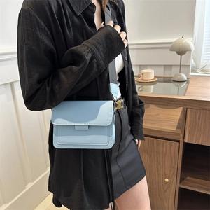 Bolso bandolera rectangular azul claro con correa ancha y herrajes dorados modernos
