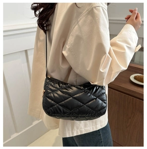 Vue détaillée du sac matelassé noir brillant avec fermeture éclair en métal doré élégant