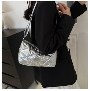 Détail du sac bandoulière argenté matelassé avec fermeture éclair dorée et sangle