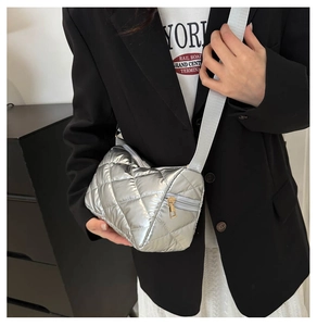 Détail du sac bandoulière argenté matelassé avec une large bandoulière élégante