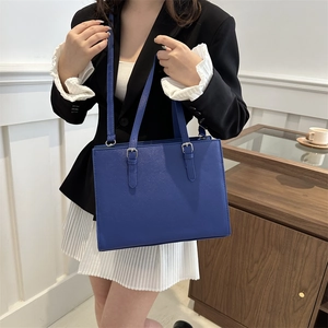 Navy blue minimalist leather tote bag with dual handles and adjustable shoulder strap