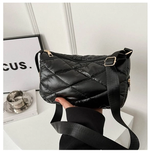 Détail du sac bandoulière matelassé noir avec sangle large et fermeture dorée