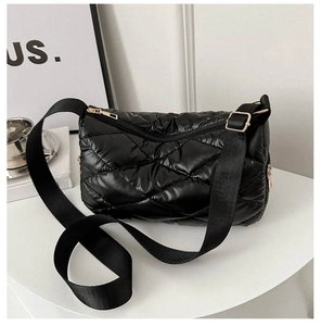 Détail d'un sac à bandoulière matelassé noir en nylon avec fermetures éclair dorées