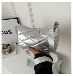 Détail du sac bandoulière argenté matelassé avec surpiqûres en losange et boucles dorées