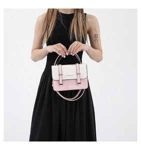 Detail view of pink and white crossbody bag with golden buckle and fashion text