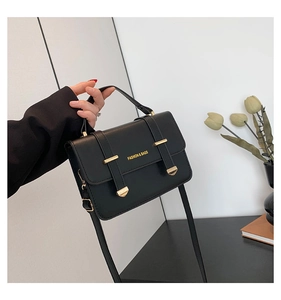 Close-up of black crossbody bag with gold hardware and FASHION & BAGS lettering