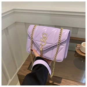 Détail du sac matelassé lilas clair avec logo doré et bandoulière en chaîne