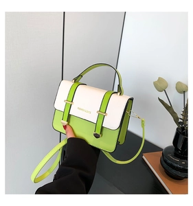 Detail of lime green and white contrast crossbody bag with fashion print and gold buckles
