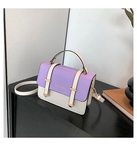 Detail of light purple flap and cream body on a textured leather crossbody bag