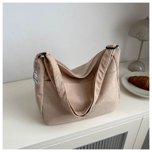 Detail of corduroy hobo bag texture with cute dog charm and adjustable strap