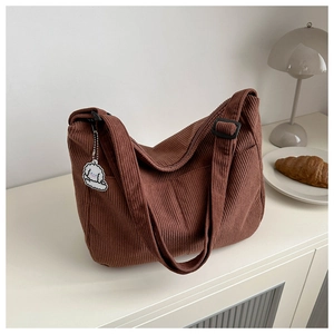 Detail of deep brown corduroy texture on tote bag with cute white cloud charm