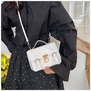 Close-up of white PU leather messenger bag with vintage gold clasp and adjustable strap