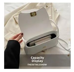 Detail view of the white shoulder bag interior showing capacity for a smartphone