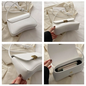 Detail view of white half-moon shoulder bag with retro metal clasp and knotted strap