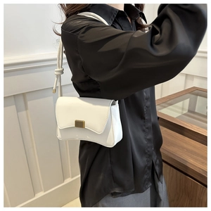 Minimalist white leather shoulder bag featuring a sleek gold rectangular metal buckle