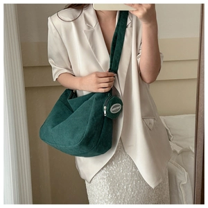 Detailed texture of dark green corduroy tote bag with round matching coin purse