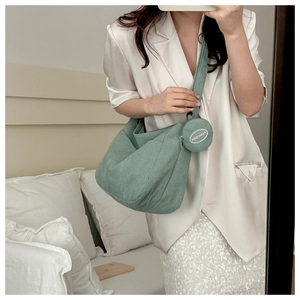 Detail of light green corduroy dumpling bag with matching round coin purse charm