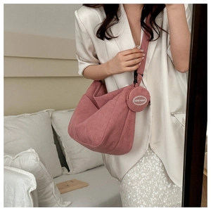 Borsa tote in velluto rosa con tasca rotonda mostrata su una modella in interni