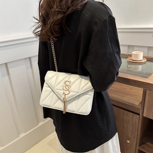 Elegant white quilted crossbody bag with gold chain strap and stylish tassel detail