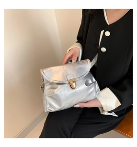 Detail of silver metallic handbag with vintage gold twist lock and stylish pleats