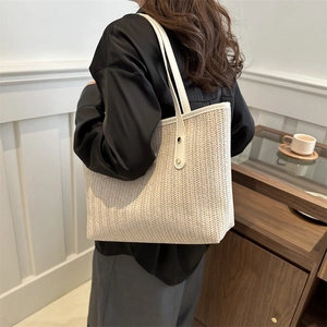 Oatmeal woven tote bag with cream leather straps shown in a modern lifestyle setting