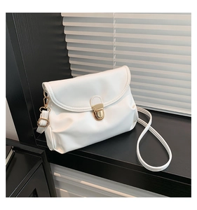 Detail of white leather shoulder bag featuring gold clasp and soft pleated design