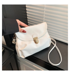 Detailed view of white PU leather crossbody bag with elegant gold metal buckle clasp