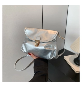 Detail of silver metallic shoulder bag featuring a vintage gold oval twist lock closure