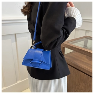 Dettaglio della piccola borsa quadrata blu brillante in pelle testurizzata con fibbia
