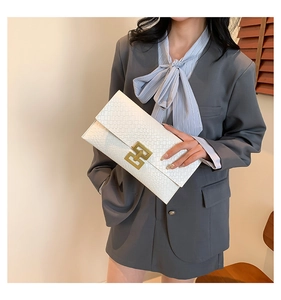 White envelope clutch featuring snakeskin texture and a gold geometric metal clasp
