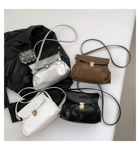 Flat lay of small crossbody square bags in four colors with gold metal clasps