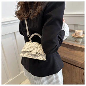 Elegante borsa a tracolla color crema con motivo marrone mostrata in stile lifestyle