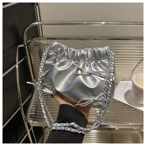 Détails du sac seau argenté avec nœuds décoratifs et bandoulière en chaîne fine