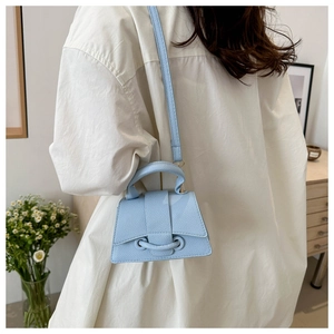 Vista dettagliata della mini borsa a tracolla azzurra in pelle testurizzata e design unico