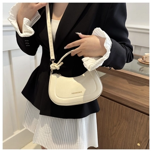Détail d'un sac à bandoulière demi-lune blanc crème avec logo doré FASHION & BAGS imprimé