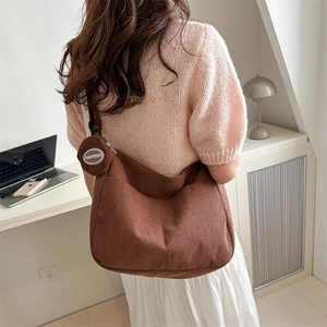 Borsa tote in velluto a coste marrone con piccola pochette rotonda indossata