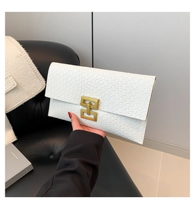 Close-up of white embossed leather envelope clutch with a gold H-shaped geometric buckle