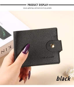 Detail of black litchi texture card holder with golden snap and embossed logo