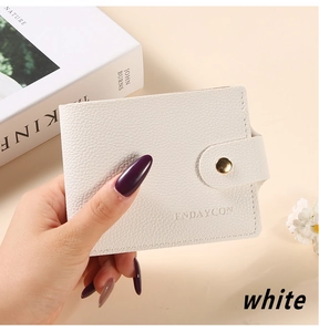 Detailed macro view of white lychee pattern leather card holder with gold snap button